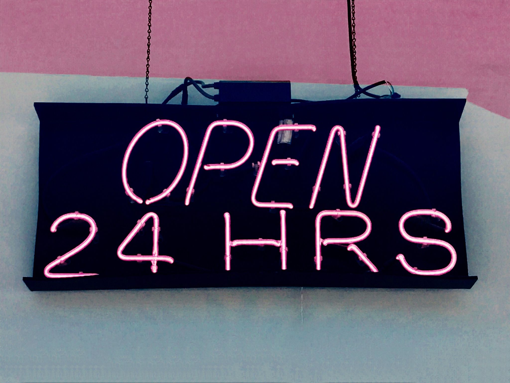 a sign with pink lights