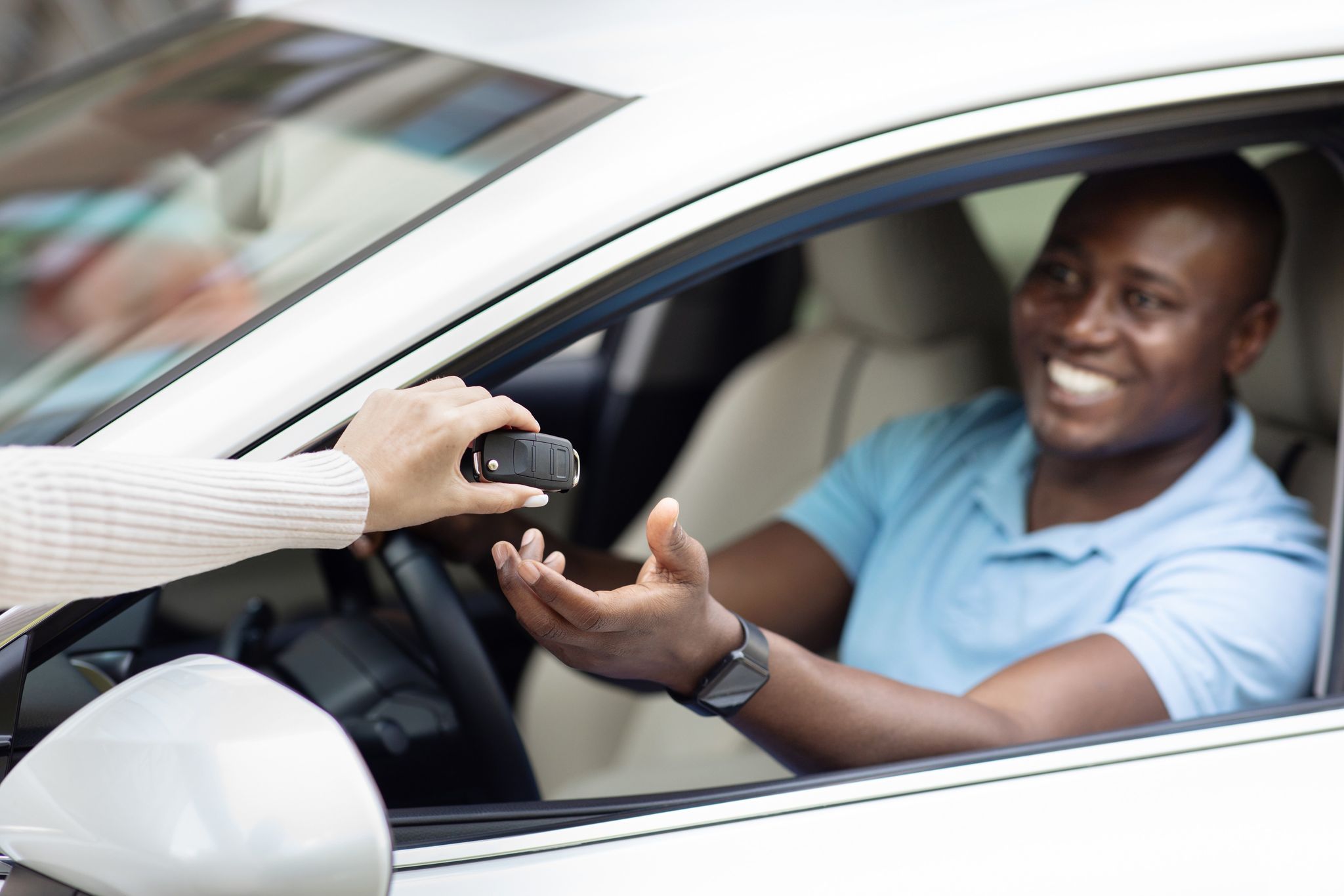 a person handing a car key to a person